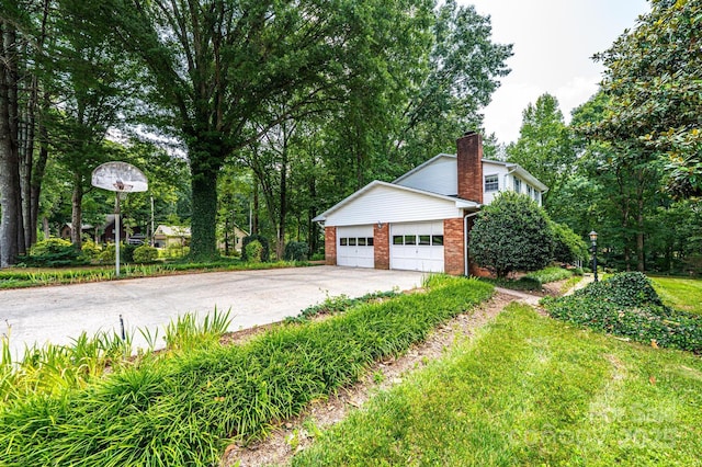3781 Dover St, Claremont, NC 28610 - view of property exterior with an attached garage, brick siding, driveway, and a chimney