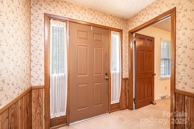 3781 Dover St, Claremont, NC 28610 - foyer entrance featuring wallpapered walls, a textured ceiling, carpet floors, crown molding, and wainscoting