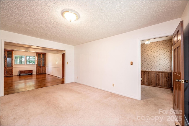 3781 Dover St, Claremont, NC 28610 - unfurnished room featuring carpet, a wainscoted wall, a textured ceiling, and wood walls