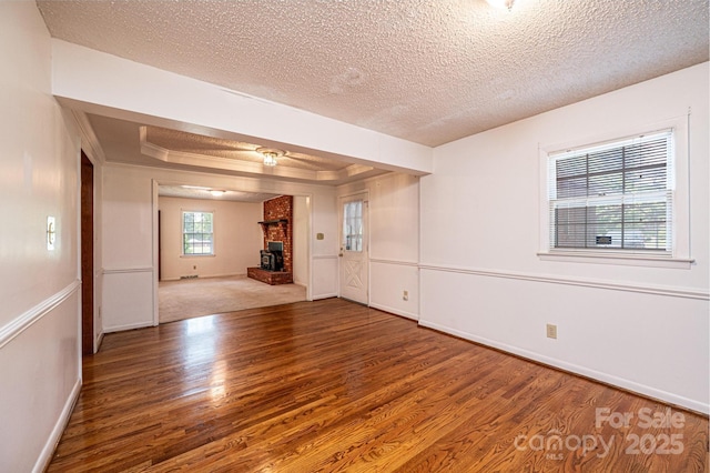 3781 Dover St, Claremont, NC 28610 - empty room with wood finished floors, a brick fireplace, and a textured ceiling