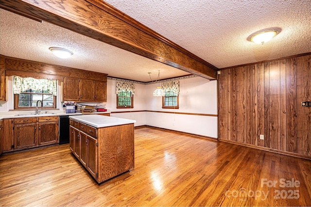 3781 Dover St, Claremont, NC 28610 - kitchen featuring a textured ceiling, light wood-type flooring, a center island, light countertops, and wooden walls