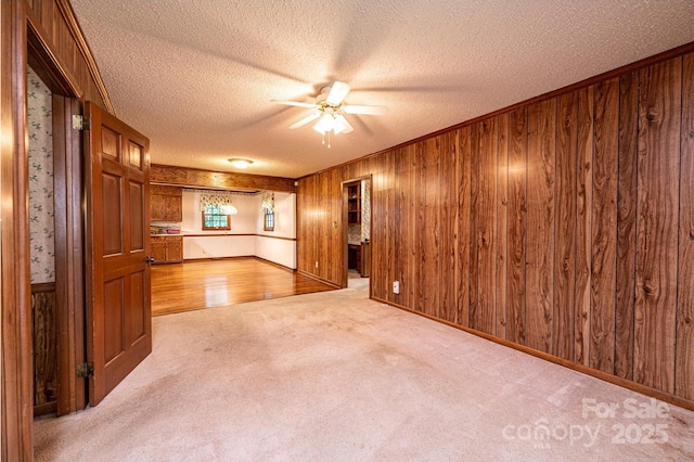 3781 Dover St, Claremont, NC 28610 - unfurnished living room featuring a textured ceiling, ceiling fan, wooden walls, and carpet flooring