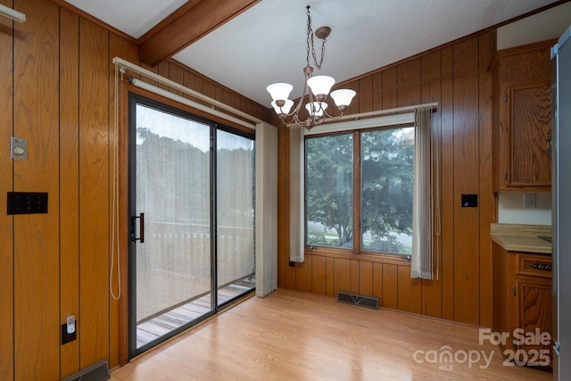 614 Azalea Ln, China Grove, NC 28023 - unfurnished dining area with wood walls, a chandelier, and light wood-style flooring