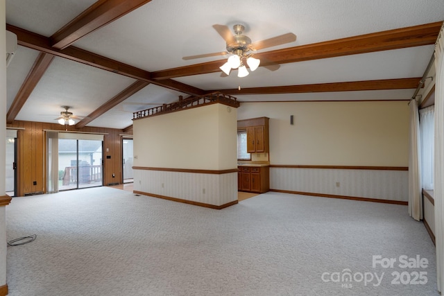 614 Azalea Ln, China Grove, NC 28023 - unfurnished living room with a ceiling fan, light carpet, wainscoting, and wooden walls