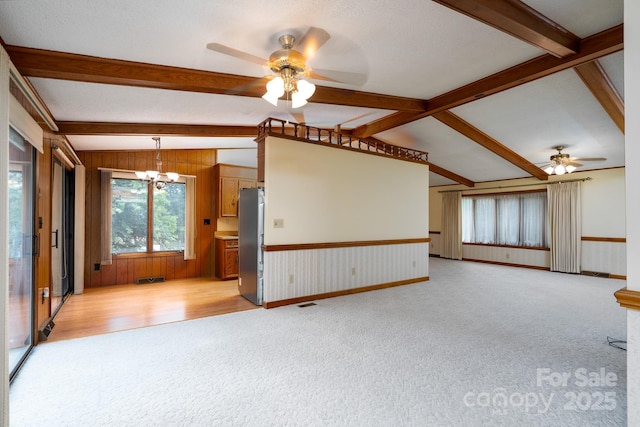 614 Azalea Ln, China Grove, NC 28023 - unfurnished living room with ceiling fan, light carpet, a chandelier, wooden walls, and a wainscoted wall