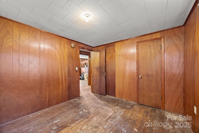 10 Manus Chapel Rd, Mill Spring, NC 28756 - unfurnished bedroom featuring wooden walls, hardwood / wood-style flooring, and a closet