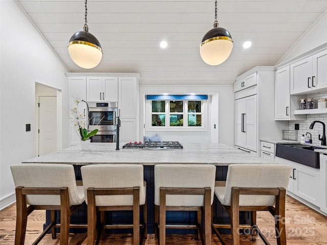 80 Raven Rock Vis, Lake Toxaway, NC 28747 - kitchen featuring appliances with stainless steel finishes, white cabinetry, decorative backsplash, light stone counters, and recessed lighting
