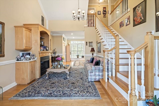 1511 Elkhart Cir, Gastonia, NC 28054 - living area with a towering ceiling, light wood finished floors, stairs, a chandelier, and ornamental molding