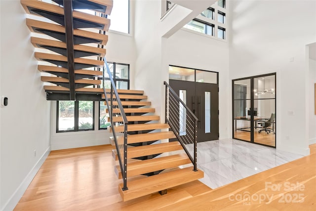 8403 Sarsfield Ct, Waxhaw, NC 28173 - entryway with stairway, a high ceiling, wood finished floors, and french doors