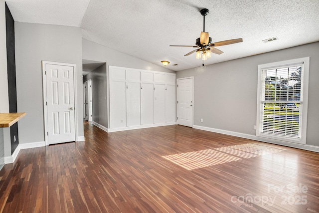 1012 Thorncrest Dr, Fletcher, NC 28732 - unfurnished living room featuring dark wood-type flooring, a ceiling fan, lofted ceiling, and a textured ceiling