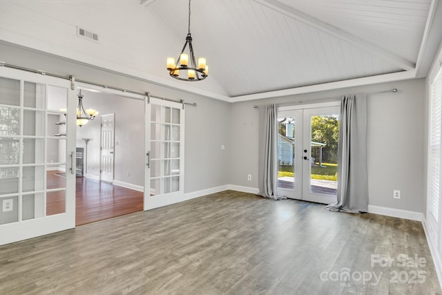 1012 Thorncrest Dr, Fletcher, NC 28732 - empty room featuring french doors, vaulted ceiling, a chandelier, wood finished floors, and a barn door