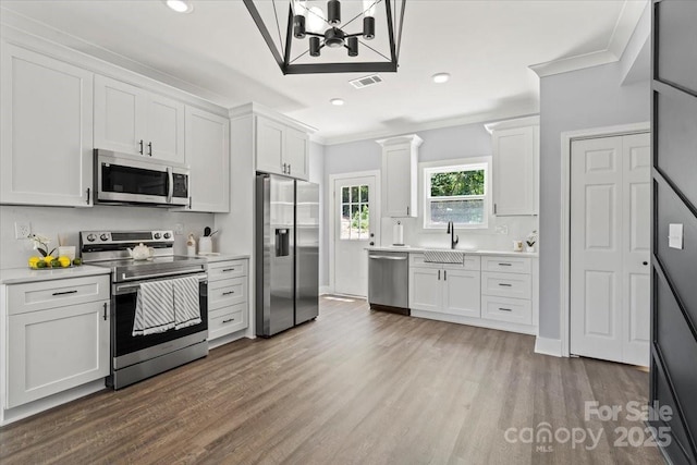 100 Boyette Dr Unit A, Albemarle, NC 28001 - kitchen with appliances with stainless steel finishes, crown molding, wood finished floors, light countertops, and white cabinetry