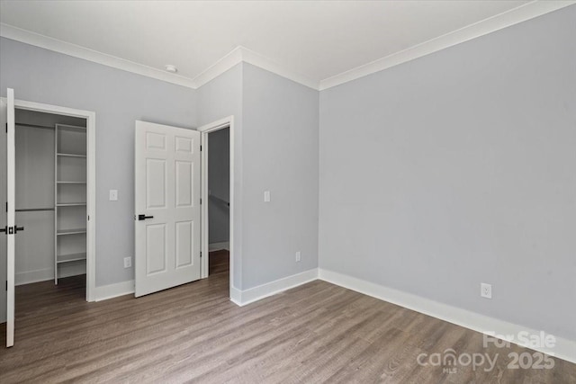 100 Boyette Dr Unit A, Albemarle, NC 28001 - unfurnished bedroom featuring crown molding, a spacious closet, and wood finished floors