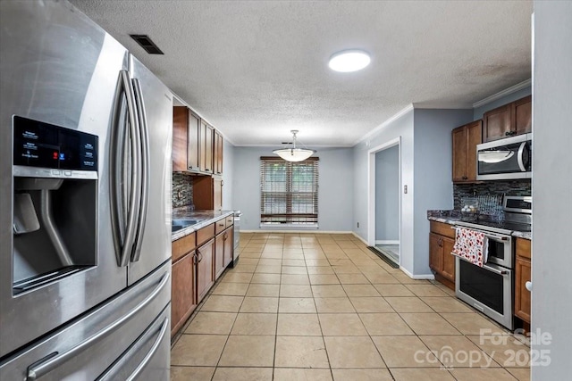 6500 Peacehaven Dr, Charlotte, NC 28214 - kitchen with appliances with stainless steel finishes, backsplash, a textured ceiling, hanging light fixtures, and light tile patterned floors