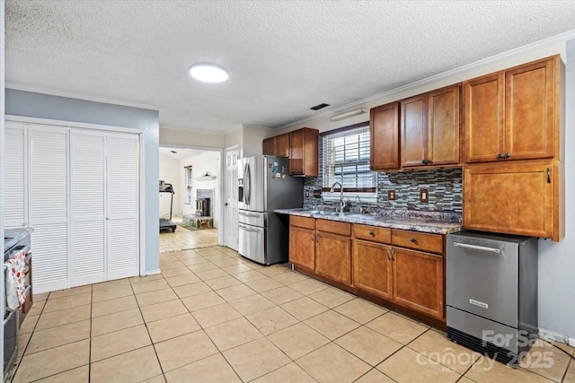 6500 Peacehaven Dr, Charlotte, NC 28214 - kitchen with stainless steel appliances, tasteful backsplash, crown molding, brown cabinetry, and light tile patterned flooring