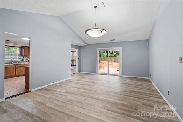 6500 Peacehaven Dr, Charlotte, NC 28214 - unfurnished living room with light wood finished floors and vaulted ceiling