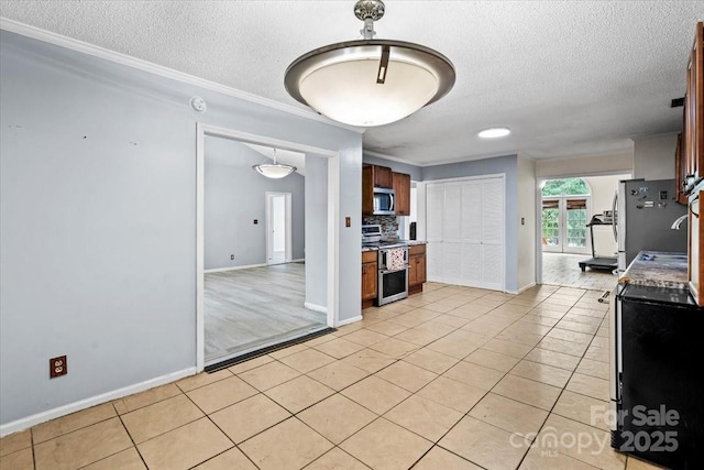 6500 Peacehaven Dr, Charlotte, NC 28214 - kitchen featuring appliances with stainless steel finishes, a textured ceiling, light tile patterned flooring, crown molding, and light countertops