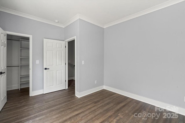 100 Boyette Dr Unit B, Albemarle, NC 28001 - unfurnished bedroom featuring a walk in closet, ornamental molding, and dark wood-style floors