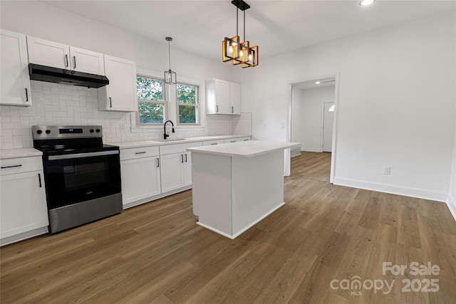 501 N Apple St Unit 103, Gastonia, NC 28054 - kitchen featuring electric stove, under cabinet range hood, backsplash, light countertops, and white cabinetry