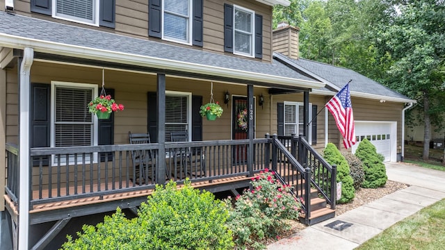 123 Clearwater Dr, Morganton, NC 28655 - property entrance featuring covered porch, a shingled roof, a garage, driveway, and a chimney