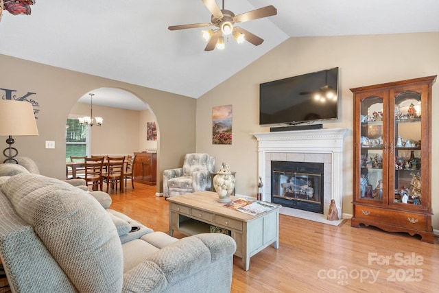 123 Clearwater Dr, Morganton, NC 28655 - living area featuring arched walkways, ceiling fan, light wood-type flooring, vaulted ceiling, and a tile fireplace