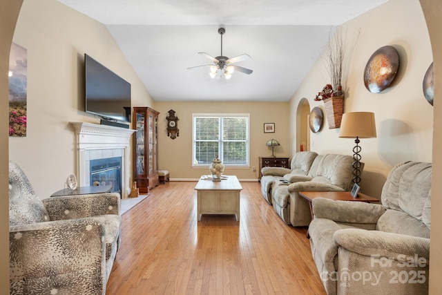 123 Clearwater Dr, Morganton, NC 28655 - living area featuring arched walkways, ceiling fan, light wood-type flooring, vaulted ceiling, and a tile fireplace