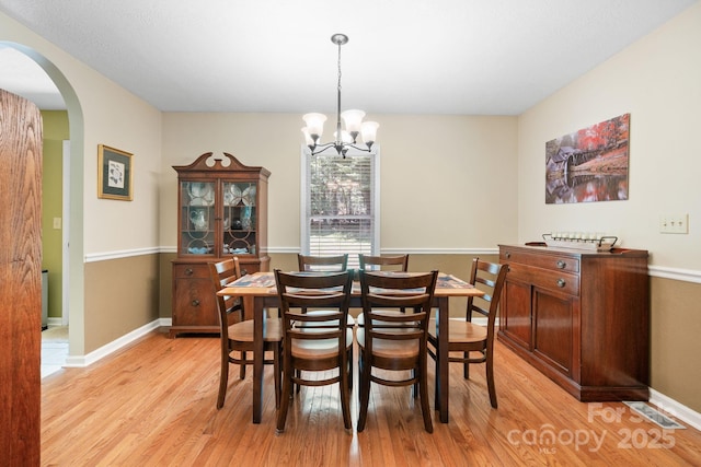 123 Clearwater Dr, Morganton, NC 28655 - dining area with light wood-style flooring, arched walkways, and a chandelier