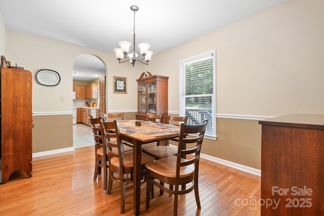 123 Clearwater Dr, Morganton, NC 28655 - dining area with arched walkways, light wood-style floors, and a chandelier