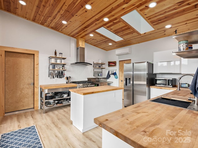511 Emerald Mine Rd, Spruce Pine, NC 28777 - kitchen with butcher block countertops, open shelves, stainless steel appliances, ventilation hood, and a wall unit AC
