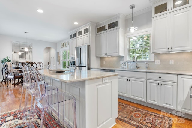 1902 4th Street Ct NW, Hickory, NC 28601 - kitchen featuring stainless steel fridge, a kitchen island, white cabinets, arched walkways, and a kitchen bar