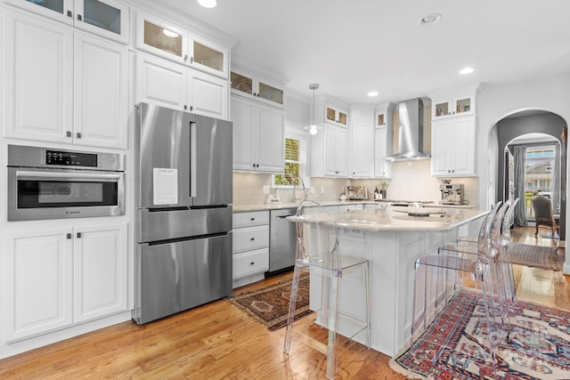 1902 4th Street Ct NW, Hickory, NC 28601 - kitchen with stainless steel appliances, arched walkways, light wood-style floors, a kitchen breakfast bar, and white cabinets