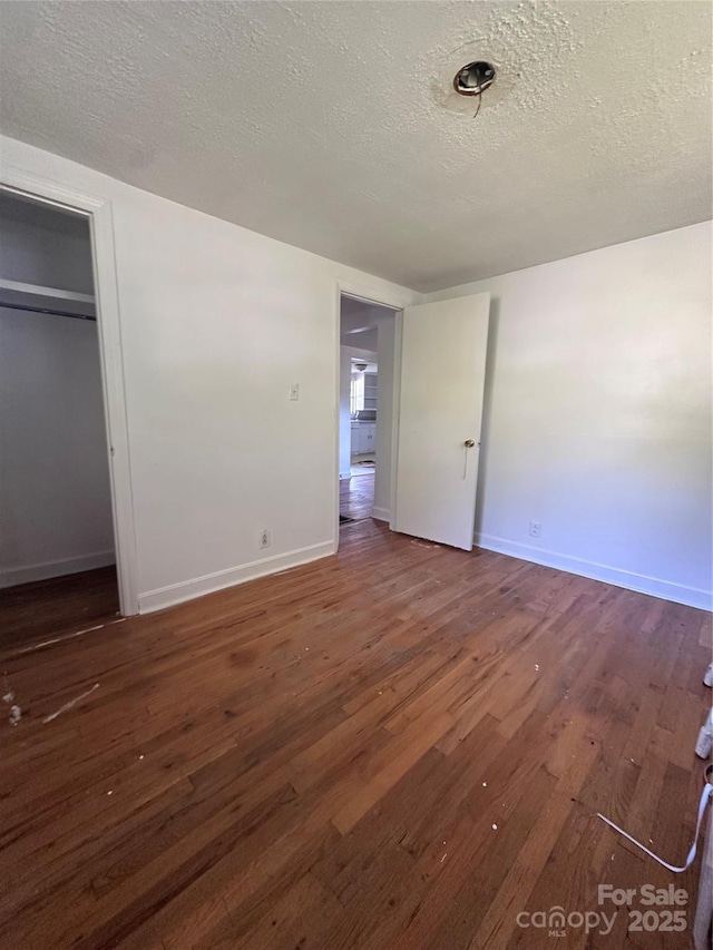508 S Ave SW, Valdese, NC 28680 - unfurnished bedroom with a textured ceiling, hardwood / wood-style floors, and a closet