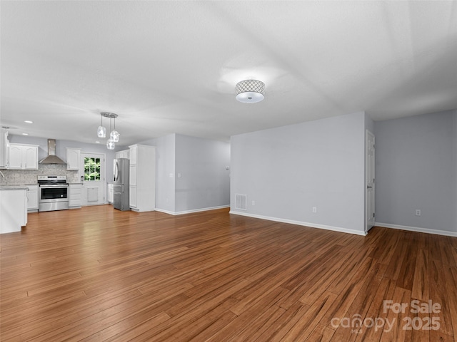 690 Mountain Rd, Hendersonville, NC 28791 - unfurnished living room with baseboards and wood finished floors