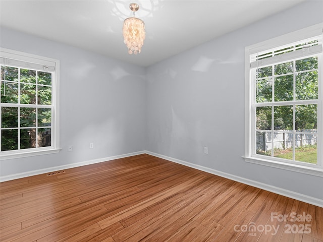 690 Mountain Rd, Hendersonville, NC 28791 - unfurnished room with wood finished floors and a chandelier