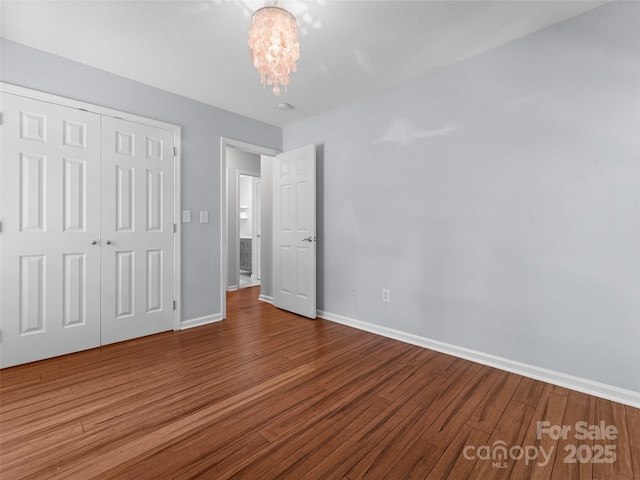 690 Mountain Rd, Hendersonville, NC 28791 - unfurnished bedroom featuring wood finished floors, a closet, and a chandelier