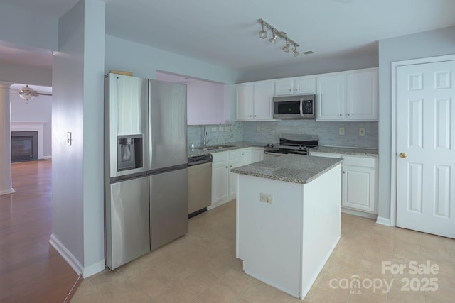 10011 Treeside Ln, Matthews, NC 28105 - kitchen featuring stainless steel appliances, tasteful backsplash, white cabinets, and a ceiling fan