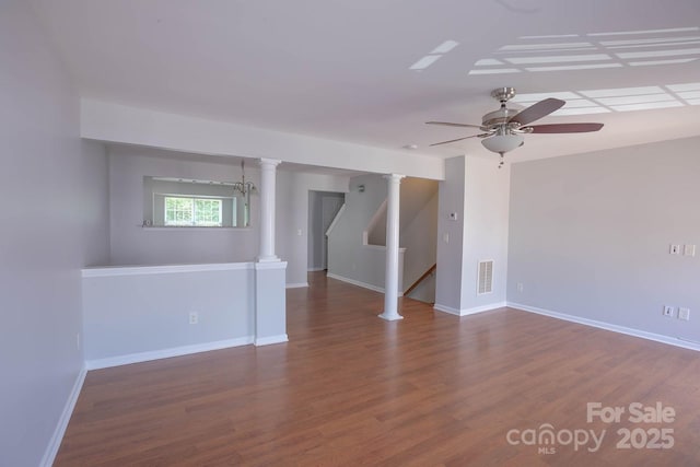 10011 Treeside Ln, Matthews, NC 28105 - spare room featuring ceiling fan, wood finished floors, stairs, and decorative columns