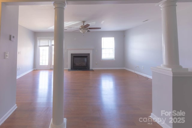 10011 Treeside Ln, Matthews, NC 28105 - unfurnished living room with ceiling fan, ornate columns, a fireplace with flush hearth, and wood finished floors