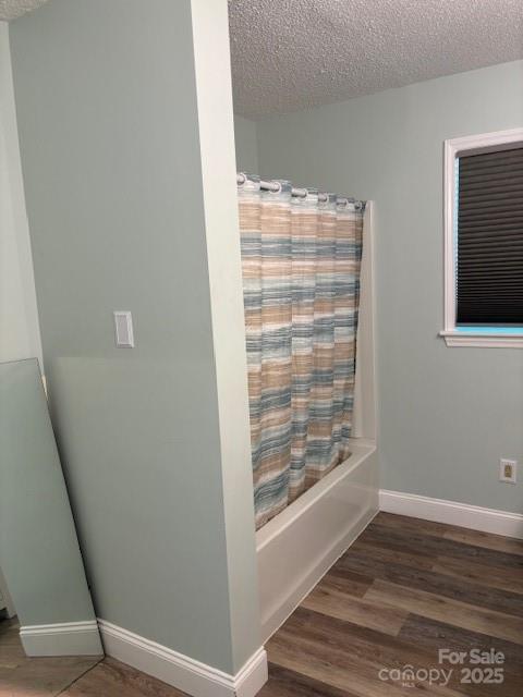 182 Redhawk Ln, Olin, NC 28660 - bathroom featuring a textured ceiling, wood finished floors, and shower / bath combination with curtain