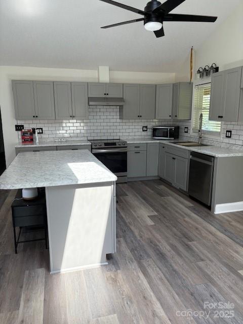 182 Redhawk Ln, Olin, NC 28660 - kitchen featuring gray cabinets, appliances with stainless steel finishes, ceiling fan, tasteful backsplash, and lofted ceiling