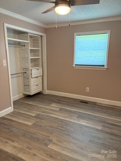 182 Redhawk Ln, Olin, NC 28660 - unfurnished bedroom featuring crown molding, a textured ceiling, a closet, dark wood finished floors, and a ceiling fan