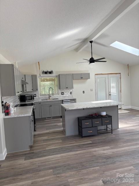 182 Redhawk Ln, Olin, NC 28660 - kitchen with gray cabinetry, a kitchen island, decorative backsplash, dark wood-style floors, and ceiling fan