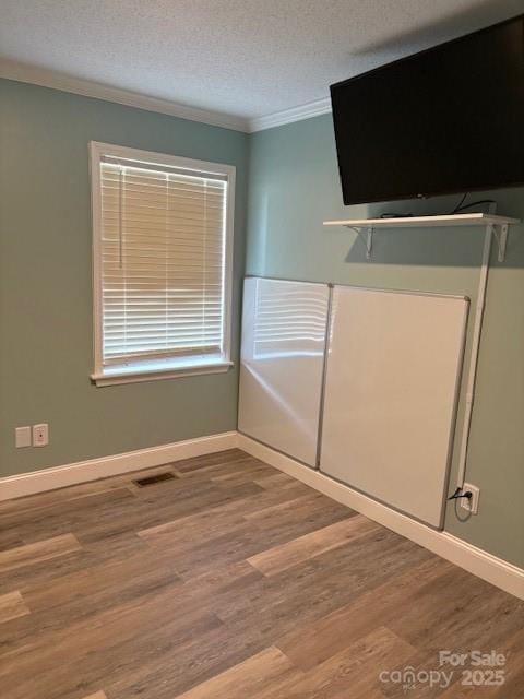 182 Redhawk Ln, Olin, NC 28660 - unfurnished bedroom featuring ornamental molding, wood finished floors, and a textured ceiling
