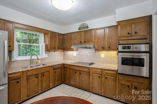 102 Boyd Dr Unit 7A, Flat Rock, NC 28731 - kitchen with appliances with stainless steel finishes, under cabinet range hood, decorative backsplash, light tile patterned floors, and a textured ceiling