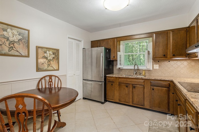 102 Boyd Dr Unit 7A, Flat Rock, NC 28731 - kitchen featuring freestanding refrigerator, black electric stovetop, decorative backsplash, light stone countertops, and a wainscoted wall