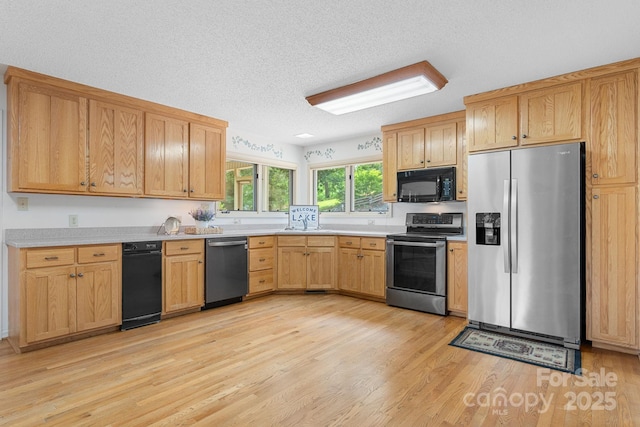 2066 Waterford Way, Morganton, NC 28655 - kitchen featuring appliances with stainless steel finishes, light wood-style floors, light countertops, and a textured ceiling