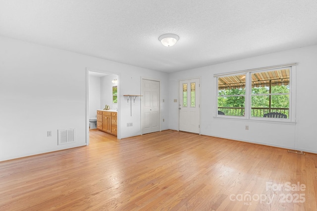 2066 Waterford Way, Morganton, NC 28655 - unfurnished living room with light wood finished floors and a textured ceiling