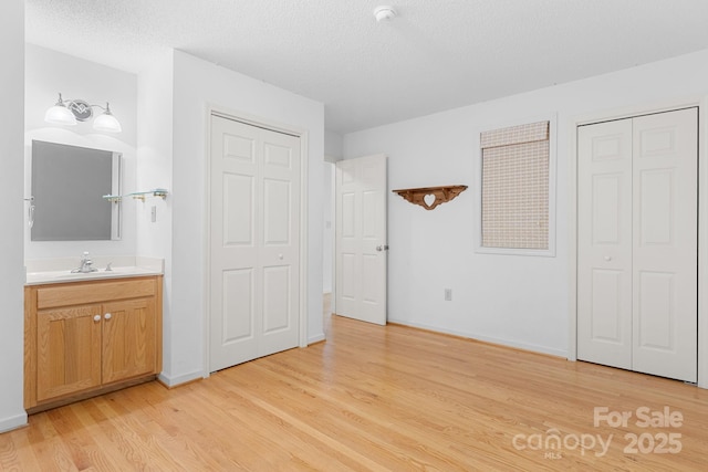 2066 Waterford Way, Morganton, NC 28655 - unfurnished bedroom featuring light wood-type flooring, connected bathroom, and a textured ceiling