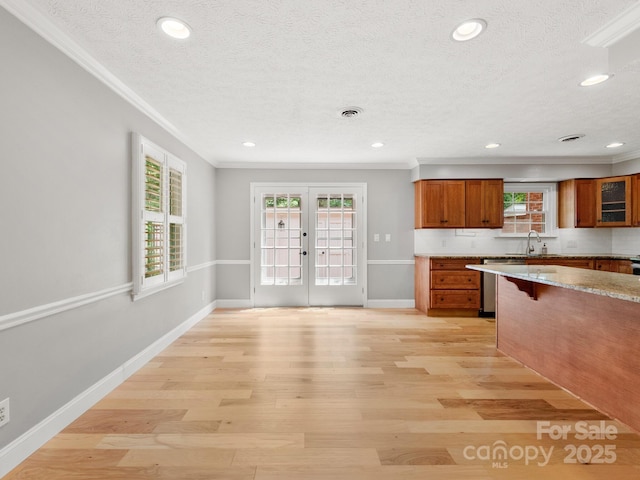 1411 Kensington Rd Unit C-1, Hendersonville, NC 28791 - kitchen featuring crown molding, brown cabinets, a textured ceiling, dishwasher, and french doors