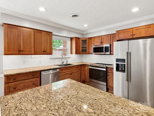 1411 Kensington Rd Unit C-1, Hendersonville, NC 28791 - kitchen with appliances with stainless steel finishes, brown cabinetry, light stone counters, glass insert cabinets, and crown molding